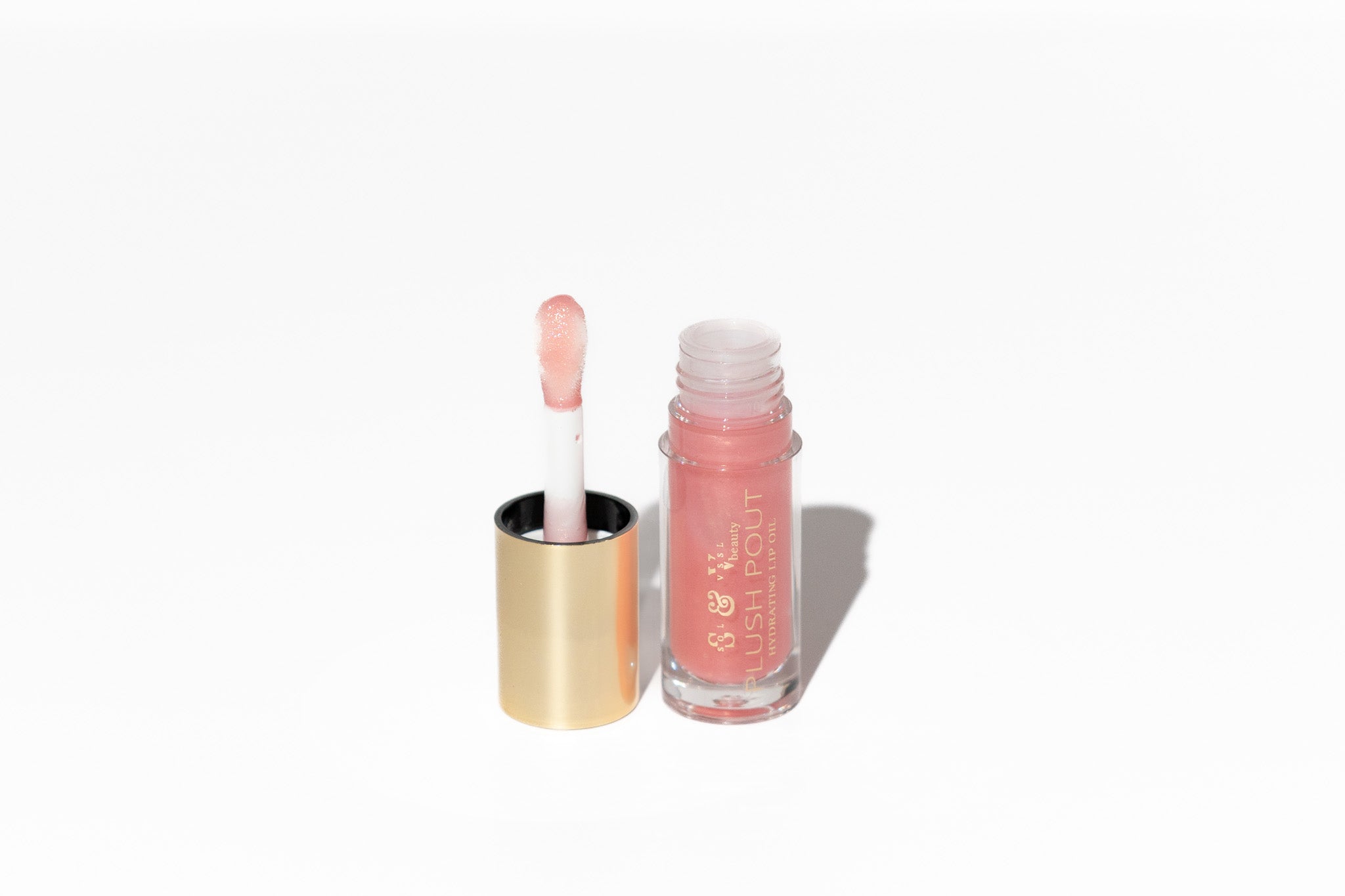 Pink lip gloss with applicator on a white background