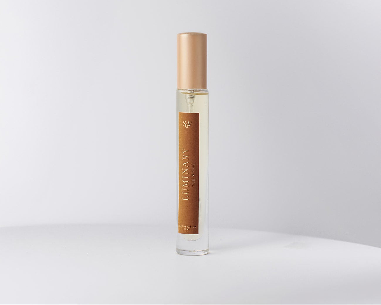 Perfume bottle with gold cap and brown label on a white background
