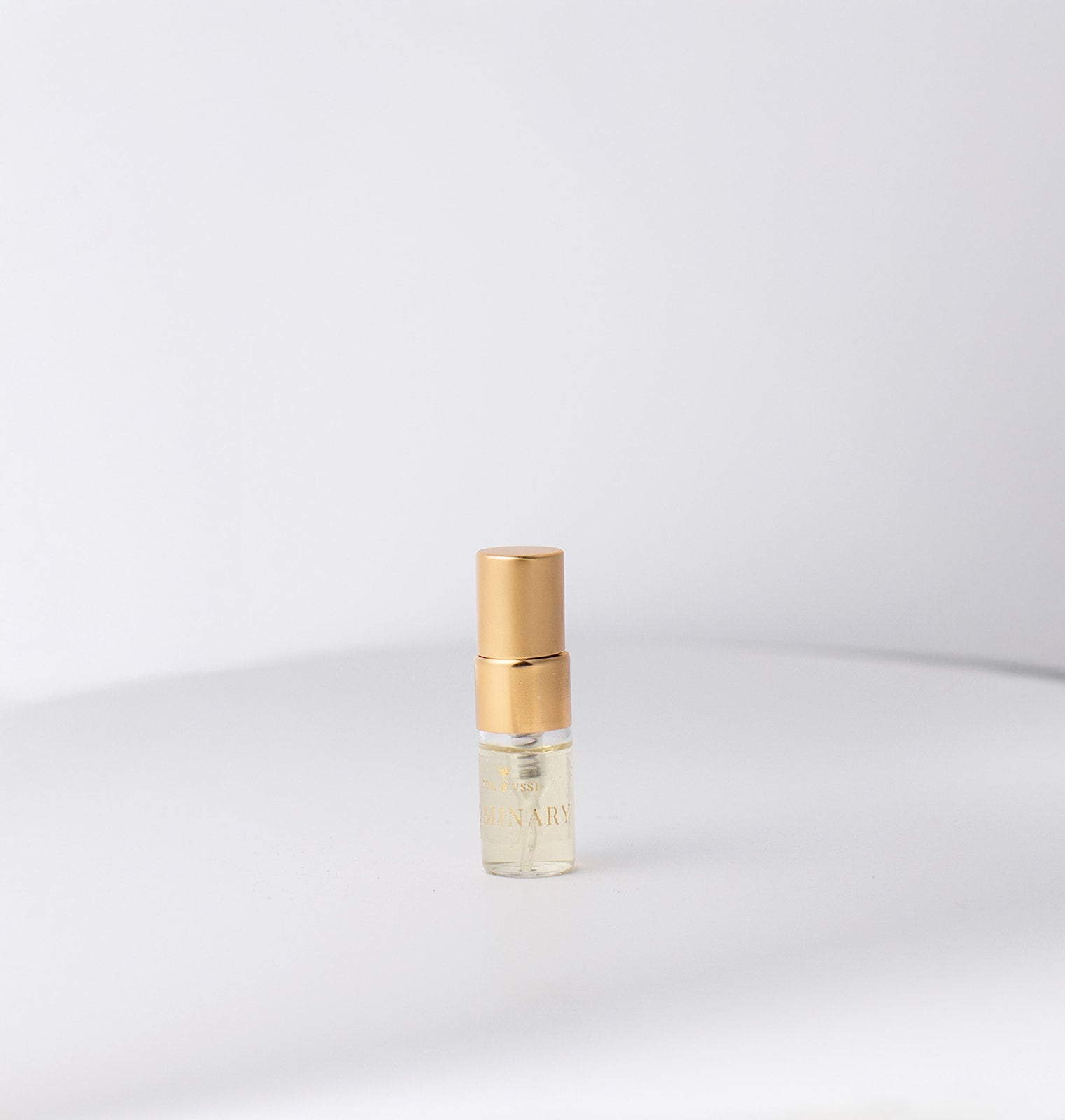 Small gold and clear bottle on a white background
